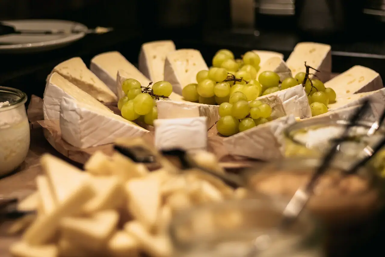 Käse Ein Teller mit Käse und Trauben.