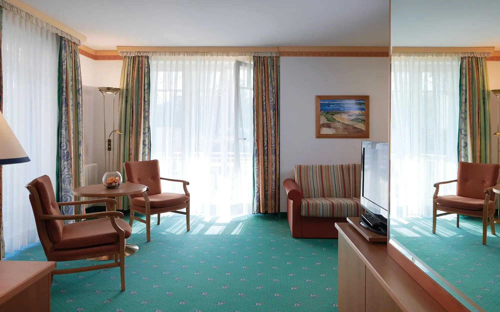 Ein Raum mit einem Fernseher und Stühlen.
