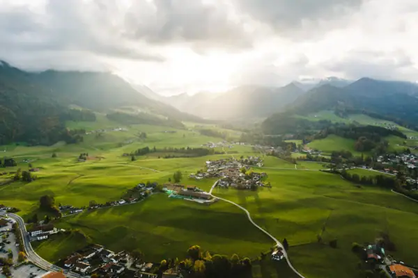 Ruhpolding Grüne Landschaft mit Bergen und Gebäuden im Vordergrund.