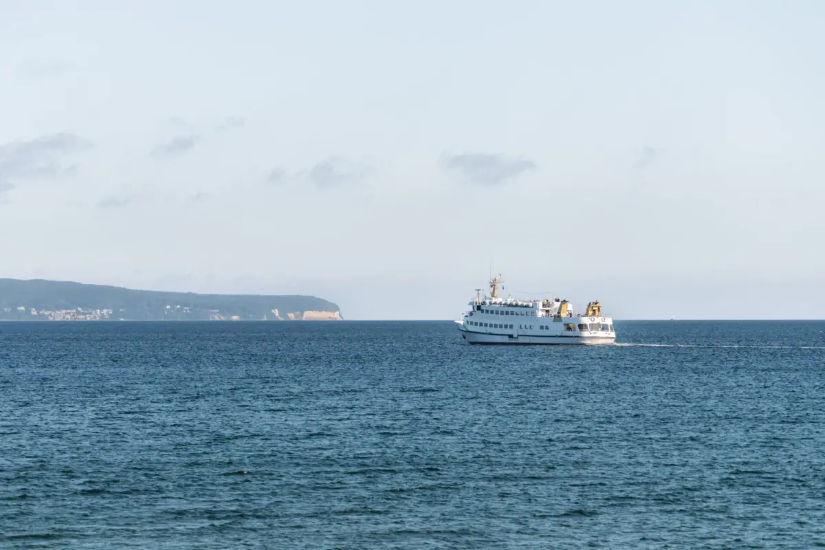 Ein Boot auf dem Wasser fährt in Richtung der Kreidefelsen auf Rügen.