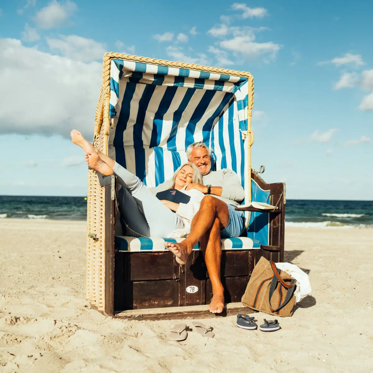 Ein Mann und eine Frau sitzen in einem Strandkorb am Strand.