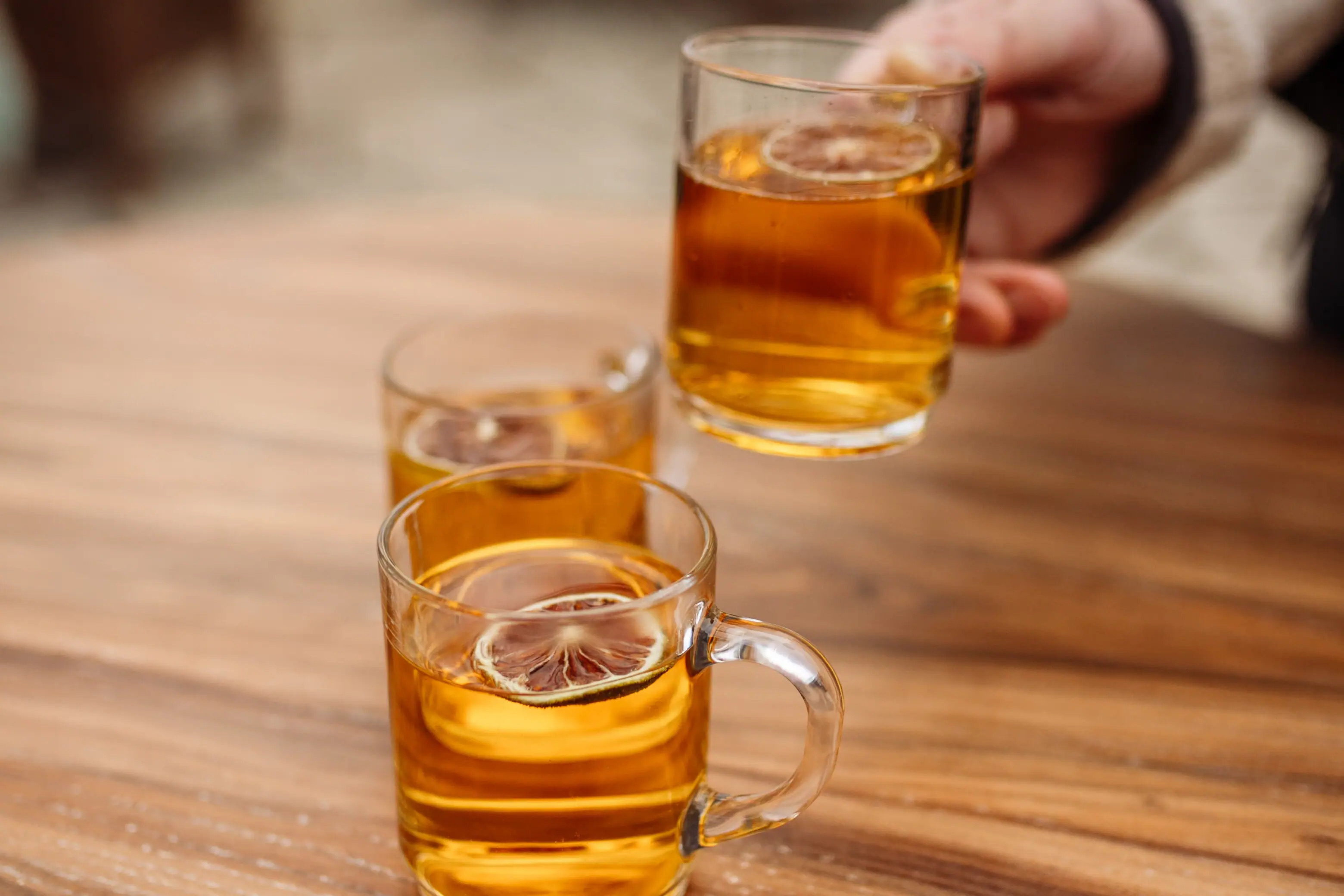 Hand hält ein Glas mit alkoholischem Getränk.