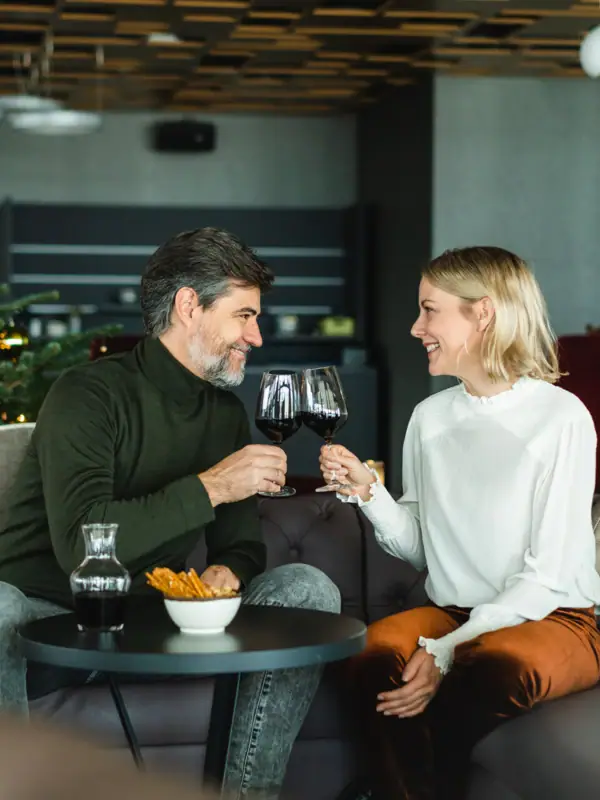 Ein Mann und eine Frau sitzen auf einem Sofa und trinken Wein.