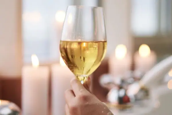 Eine Hand hält ein Weinglas.