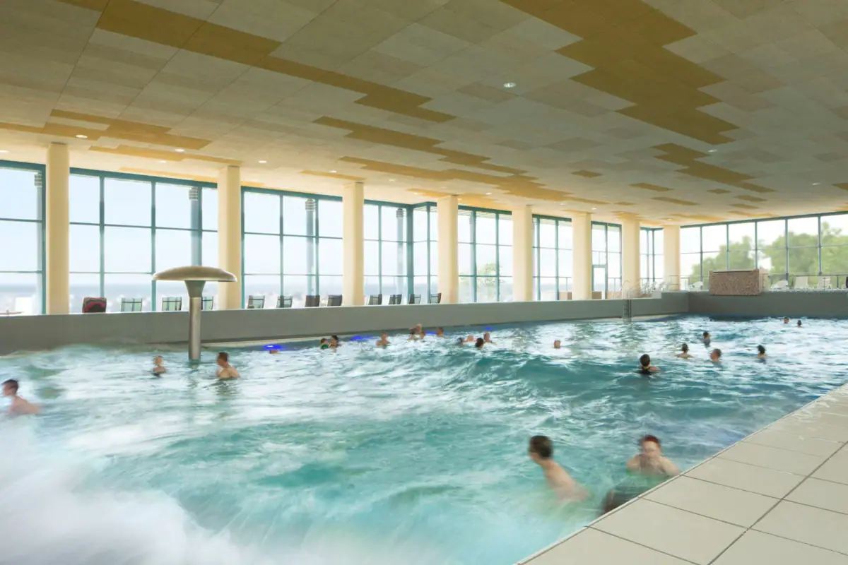 Ein großes Hallenbad mit Menschen, die darin schwimmen.