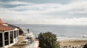 An einem Strand stehen viele weiße Strandkörbe und im Hintergrund ist das aja Bansin zu sehen.