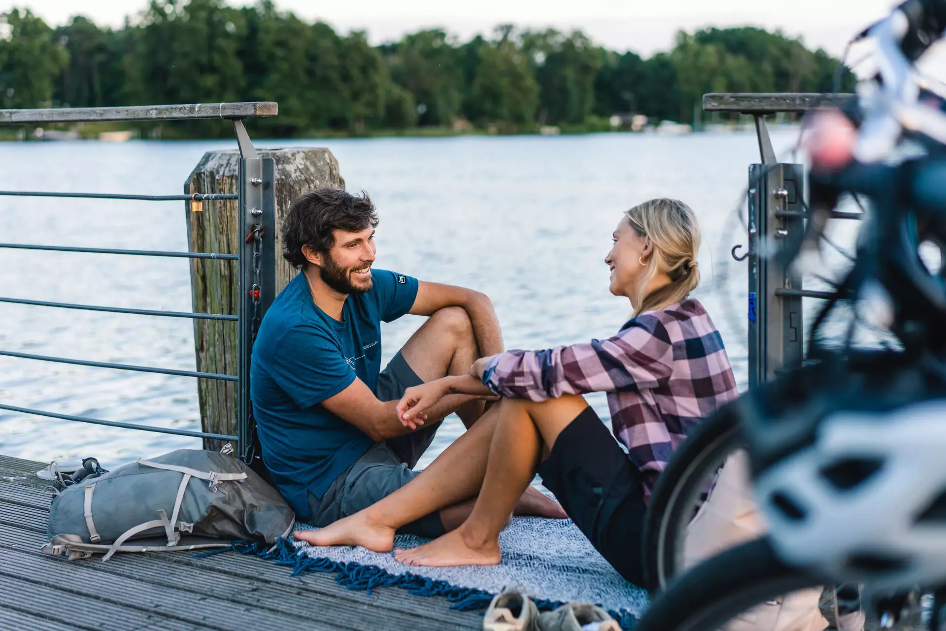 Ein Mann und eine Frau sitzen auf einem Dock am Wasser.