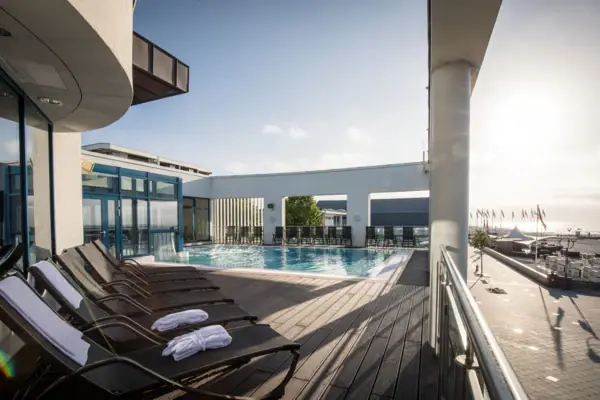 Ein Pool mit Liegestühlen und einem Deck im SPA Bereich des aja Grömitz bzw. der Grömitzer Welle..