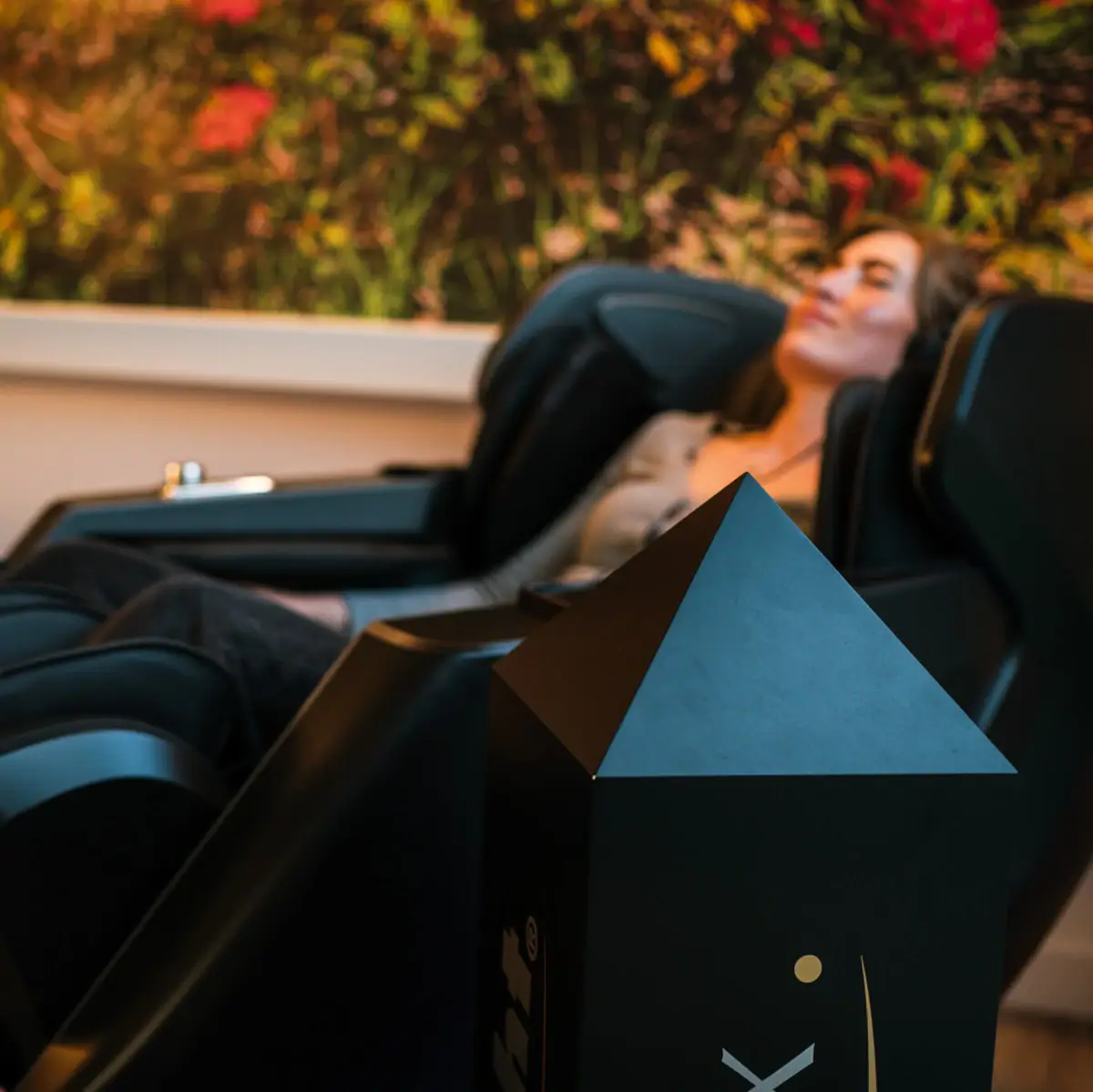 Eine Frau liegt in einem Massagestuhl.