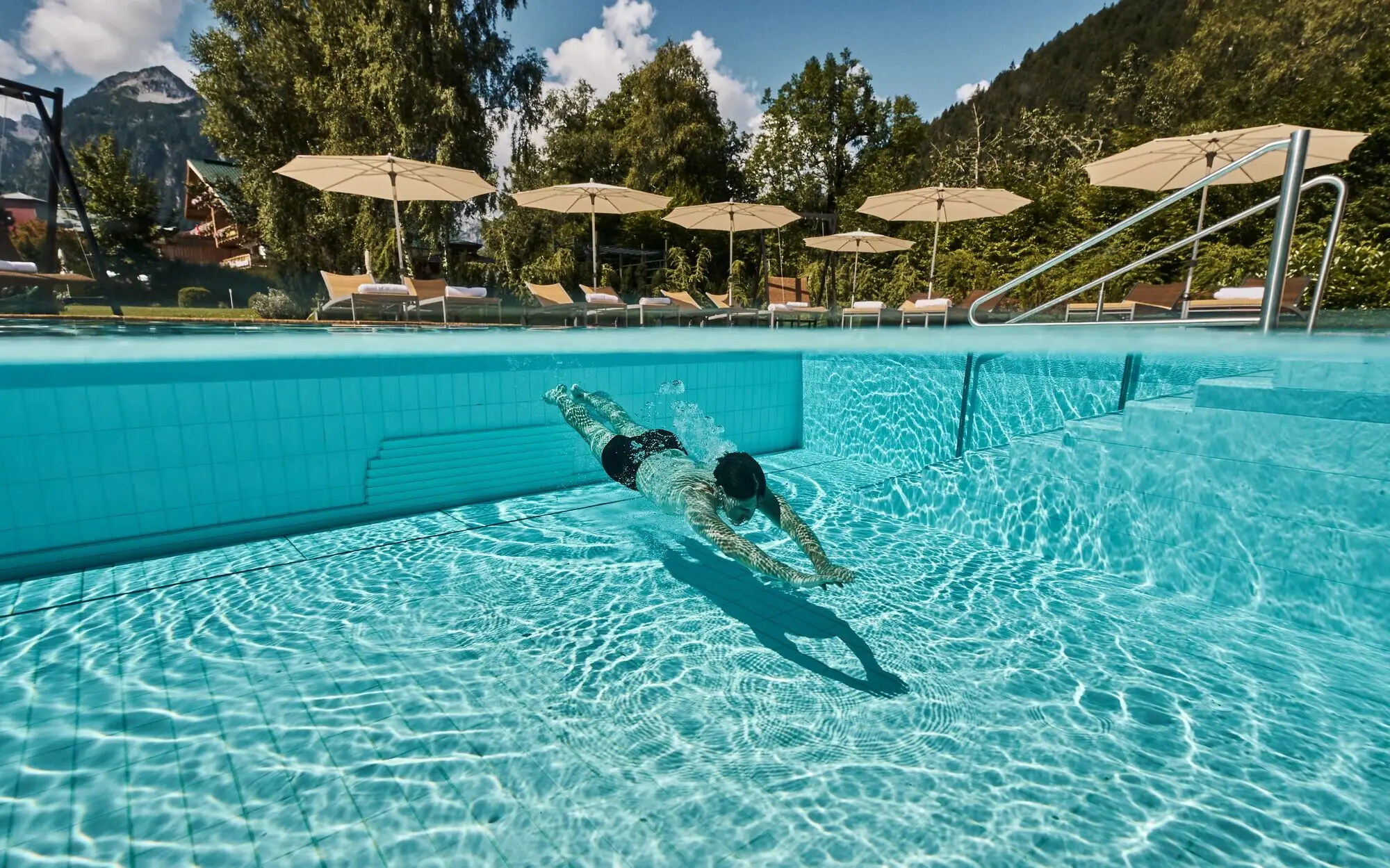 Person schwimmt in einem Außenpool.