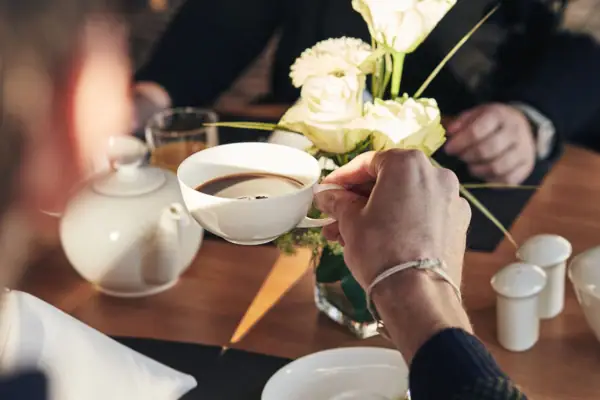 Eine Person hält eine Tasse Kaffee.