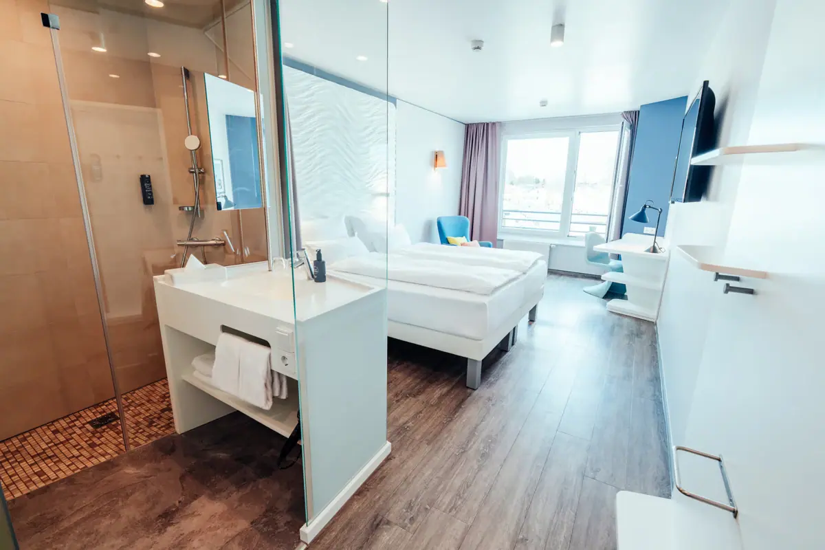 Ein Raum mit zwei Betten und einer Dusche.