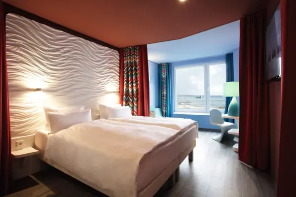 Hotelzimmer Grömitz Ein Zimmer mit einem Bett und einem Fenster.