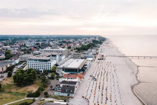 Strand mit vielen Strandkörben und Gebäuden aus der Vogelperspektive.