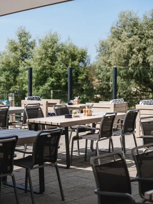 Restaurant und Bar im aja Warnemünde Ein Tisch und Stühle auf einer Terrasse.