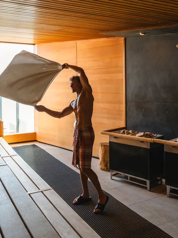 Ein Mann hält ein Handtuch in einem Raum.