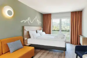 Doppelzimmer Bergblick aja Ruhpolding Ein Zimmer mit zwei Betten und einem Sofa.