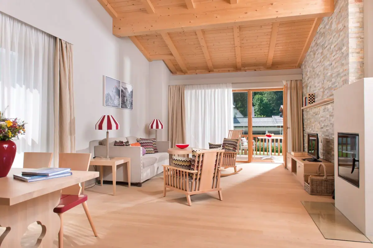 Ferienwohnungen Werfenweng Wohnzimmer mit Kamin und Sofa.