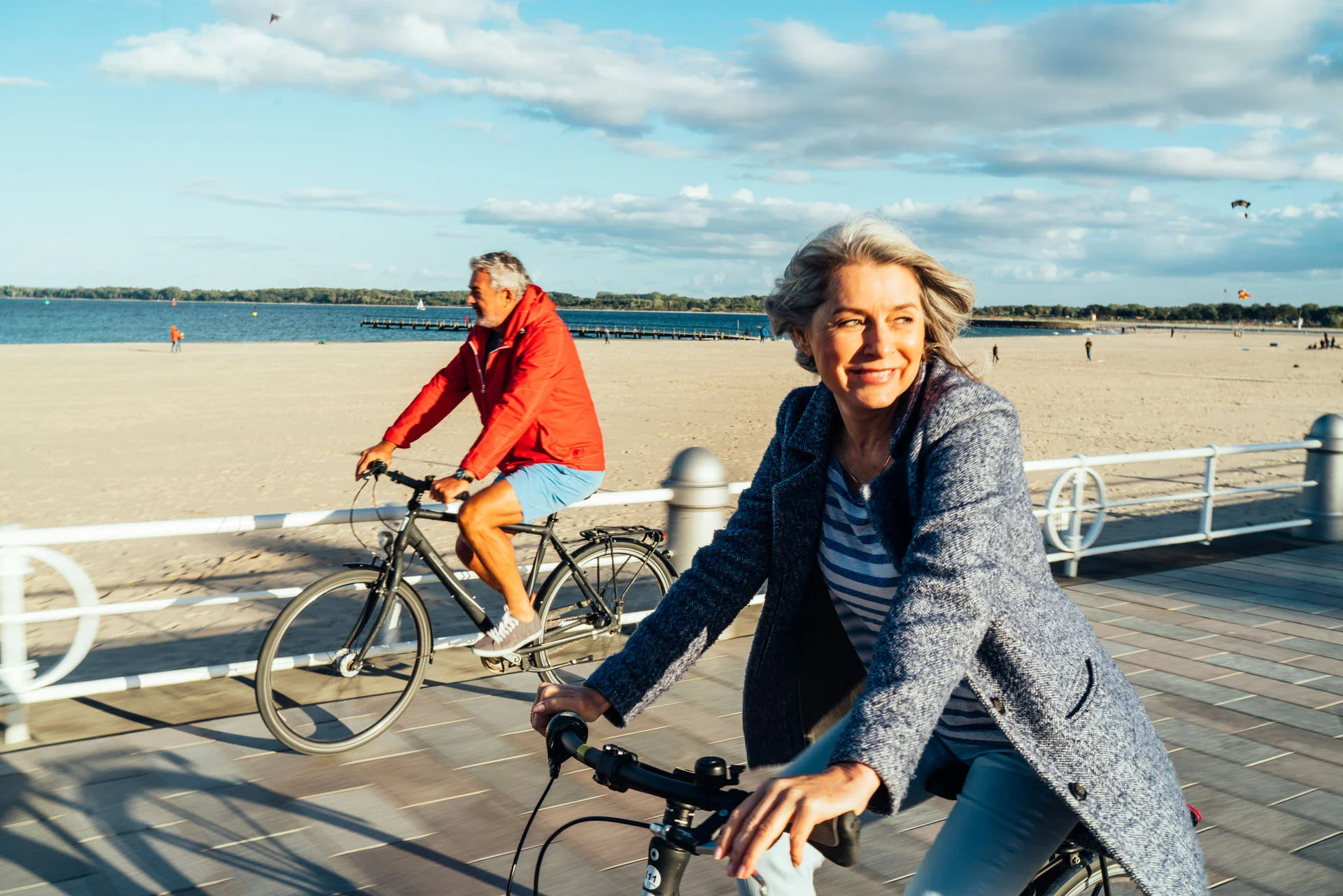 Ein Mann und eine Frau fahren mit Fahrrädern an einer Strandpromenade