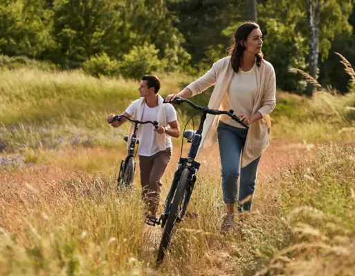 Radfahren Ein Mann und eine Frau fahren auf Fahrrädern durch ein Feld.