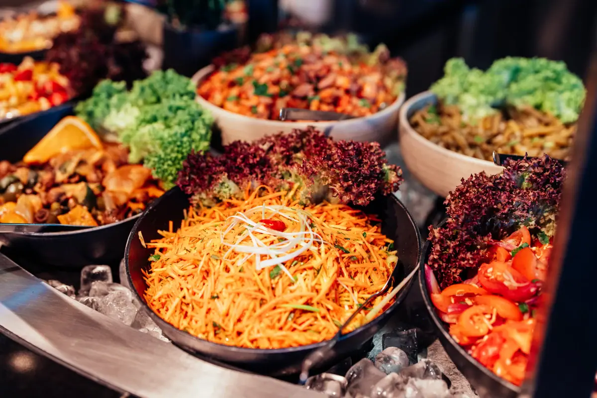 Buffet im JEDERMANNS Eine Gruppe von Schüsseln mit verschiedenen Speisen.