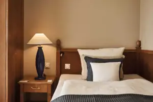 Doppelzimmer Ein Bett mit einer Lampe auf einem Nachttisch.