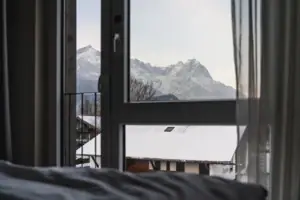 Ausblick Winter Blick aus einem Fenster auf schneebedeckte Berge