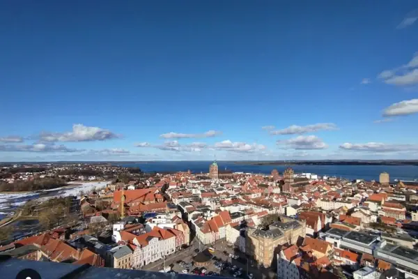 Stralsund Eine Stadt mit roten Dächern und einem Gewässer.