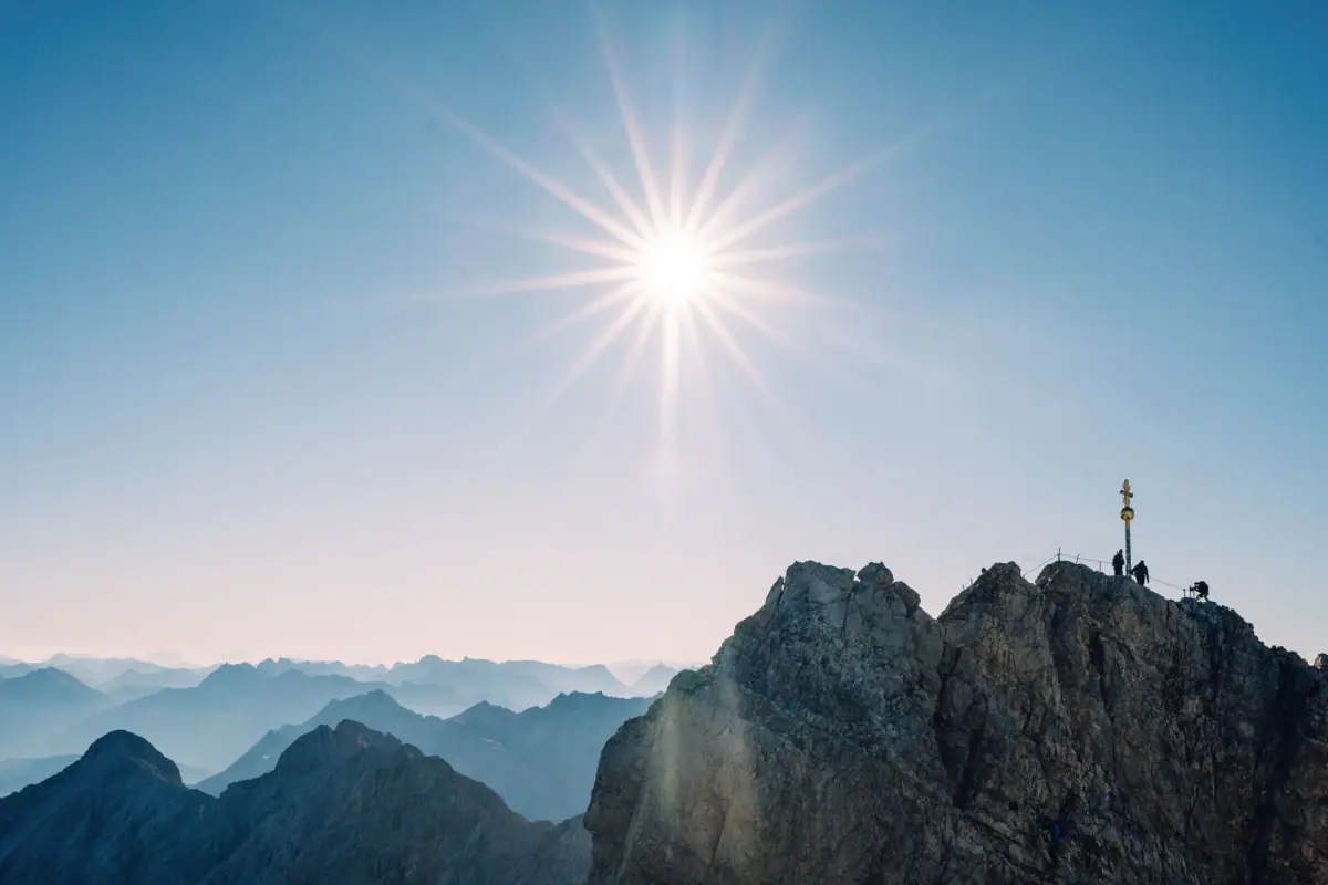 Zugspitze Sommer Sonne scheint über der Zugspitze mit Gipfelkreuz.