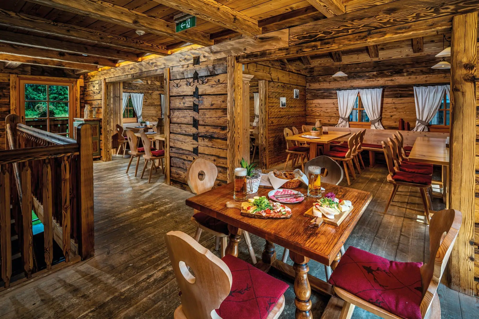 Ein Gastraum mit Tischen und Stühlen sowie einem Tisch mit Essen.