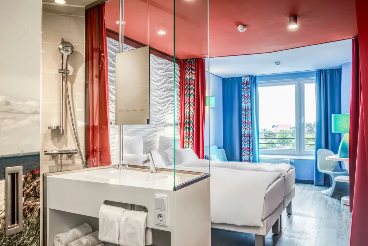 aja Grömitz Zimmer Ein Zimmer mit einem Doppelbett und einem Waschbecken.