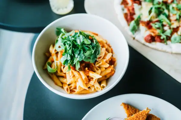 Eine Schüssel Pasta mit Sauce und Petersilie.