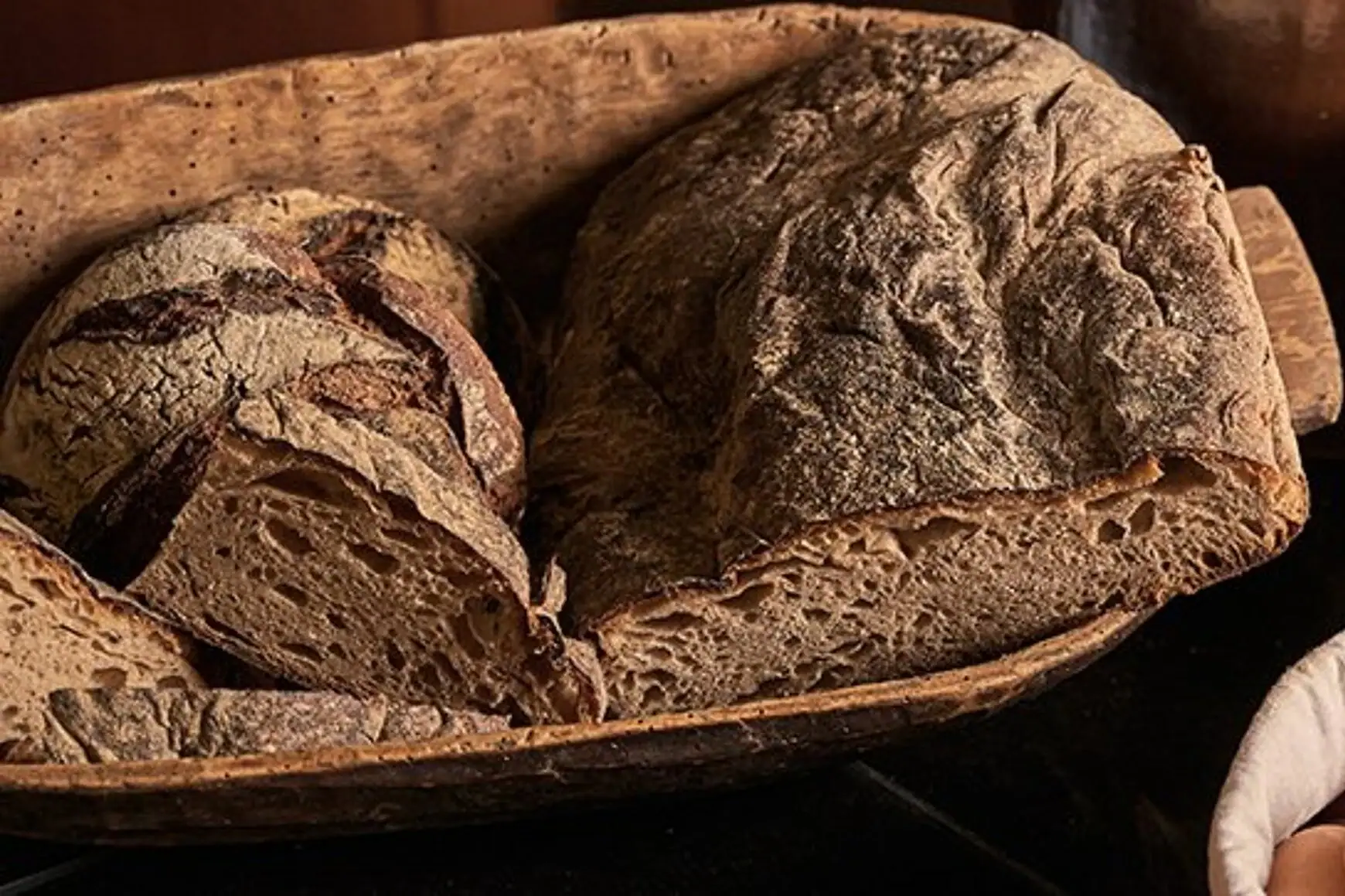 Ein Laib Brot und Eier in einem Korb neben einem Glas Milch.