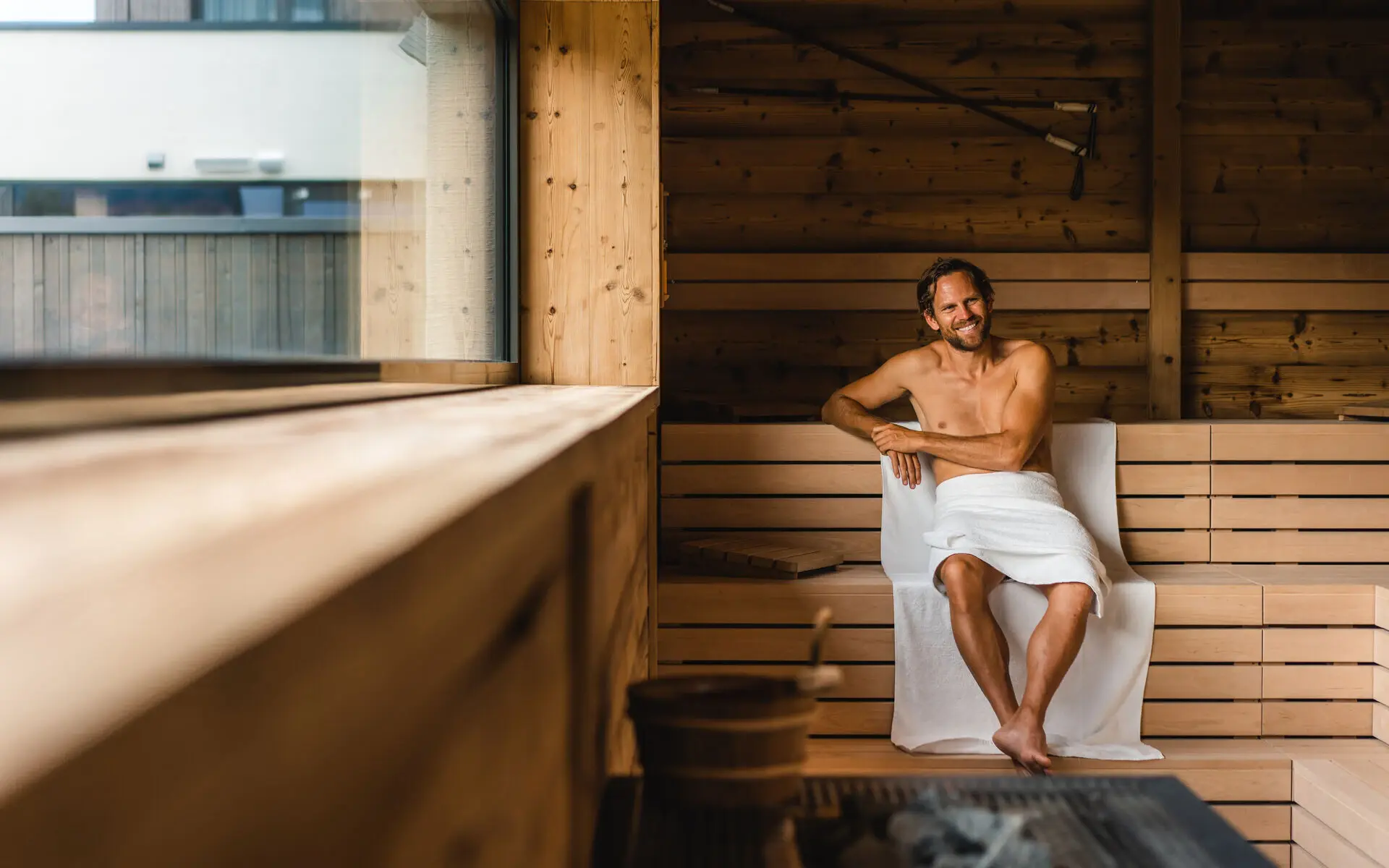 Mann sitzt in einer Sauna.