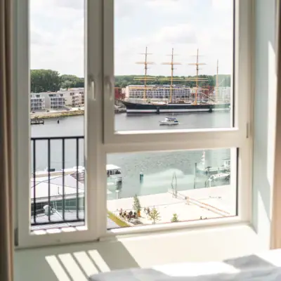 Zimmer im aja Travemünde Blick aus einem Fenster auf die Passat im Hafen.
