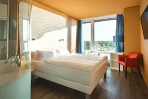 Zimmer im aja Warnemünde Ein Zimmer mit einem Bett, einem Schreibtisch und einem Stuhl.