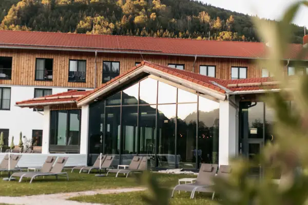 Ein Gebäude mit Liegestühlen und einem Berg im Hintergrund.