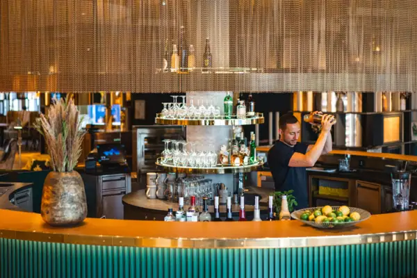 Ein Mann schenkt ein Getränk in einer Bar ein.