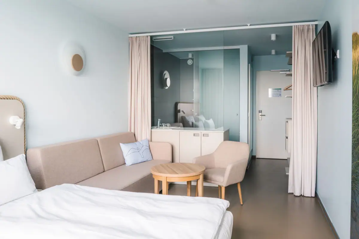 Zimmer im aja Travemünde Ein Zimmer mit einem Sofa und einem Tisch.