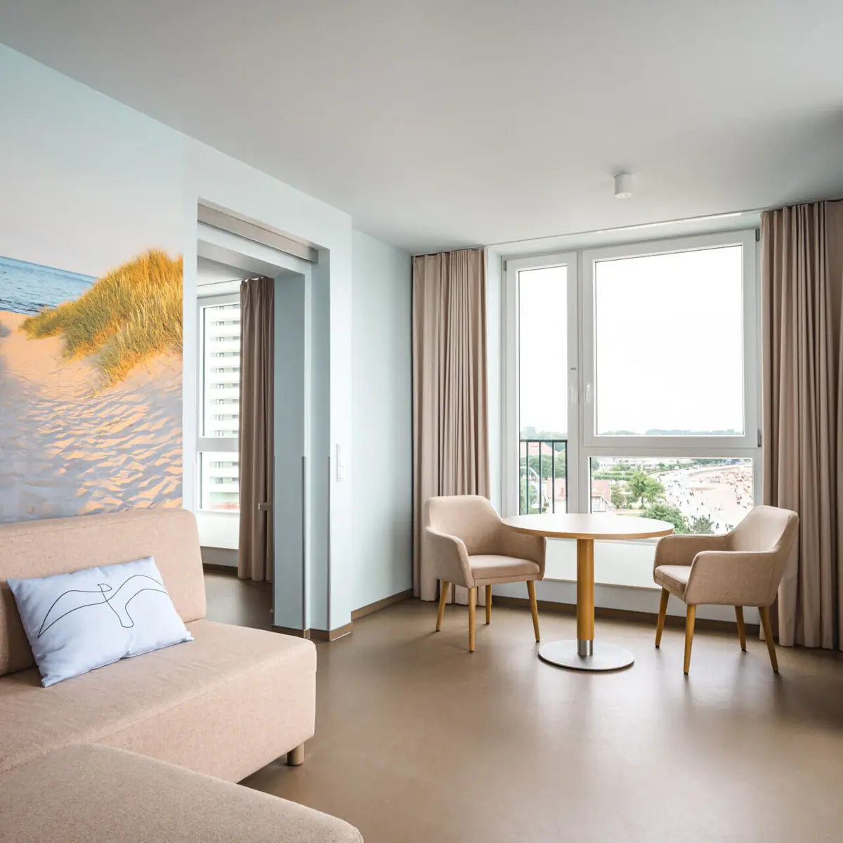 Suite im aja Travemünde Ein Wohnzimmer mit Sofa und Stühlen.