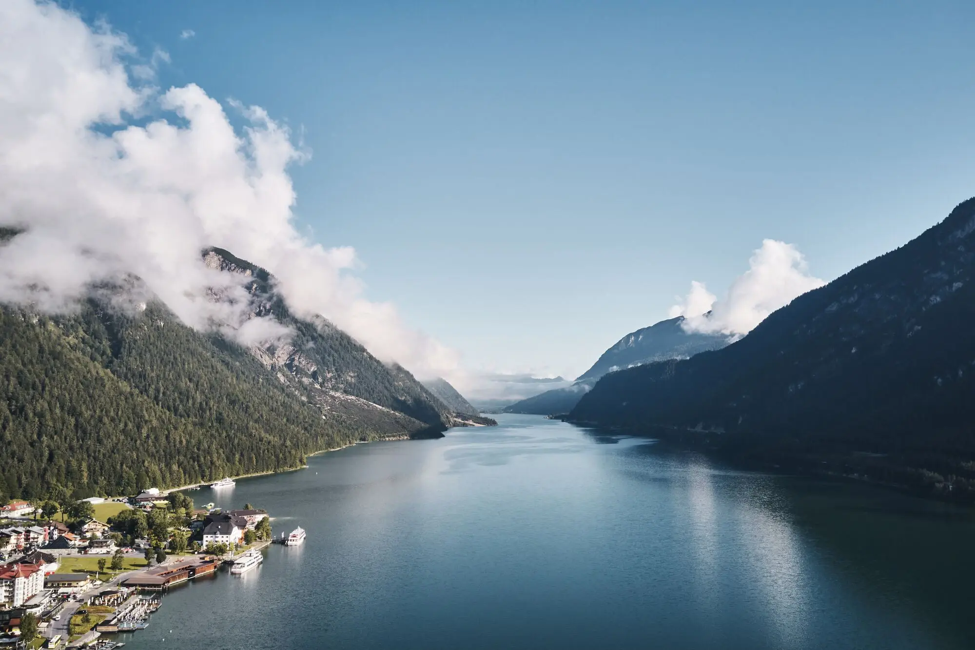 Luftaufnahme des Achensees mit Bergen im Hintergrund.