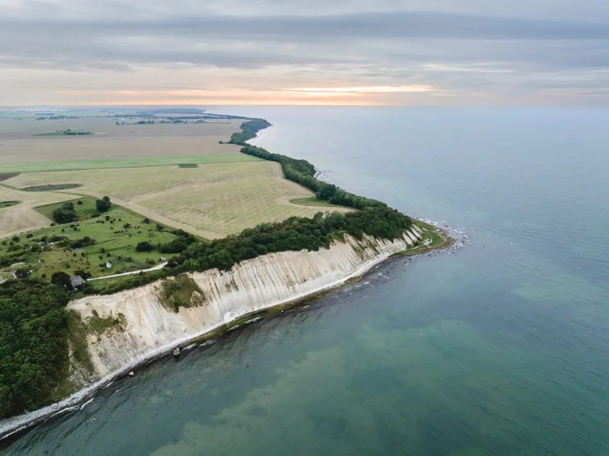 Küstenlandschaft mit Wasser und Himmel im Hintergrund.