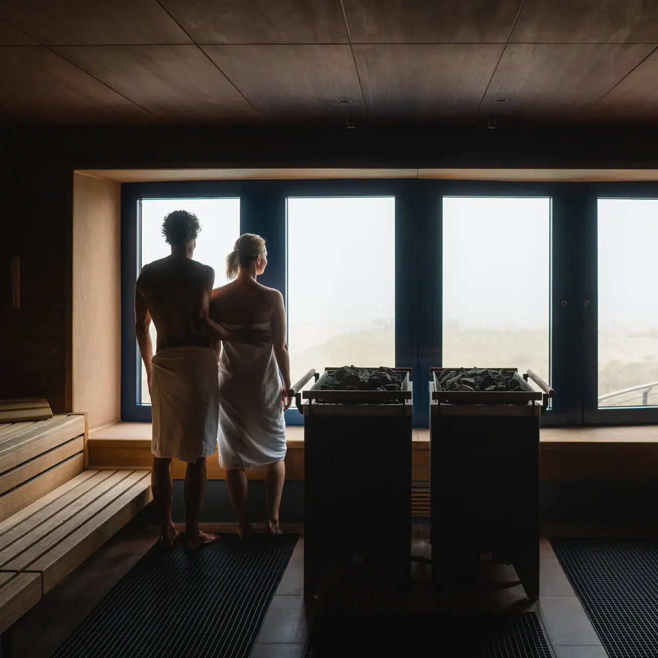 Sauna im aja Warnemünde Ein Mann und eine Frau stehen in einer Sauna.