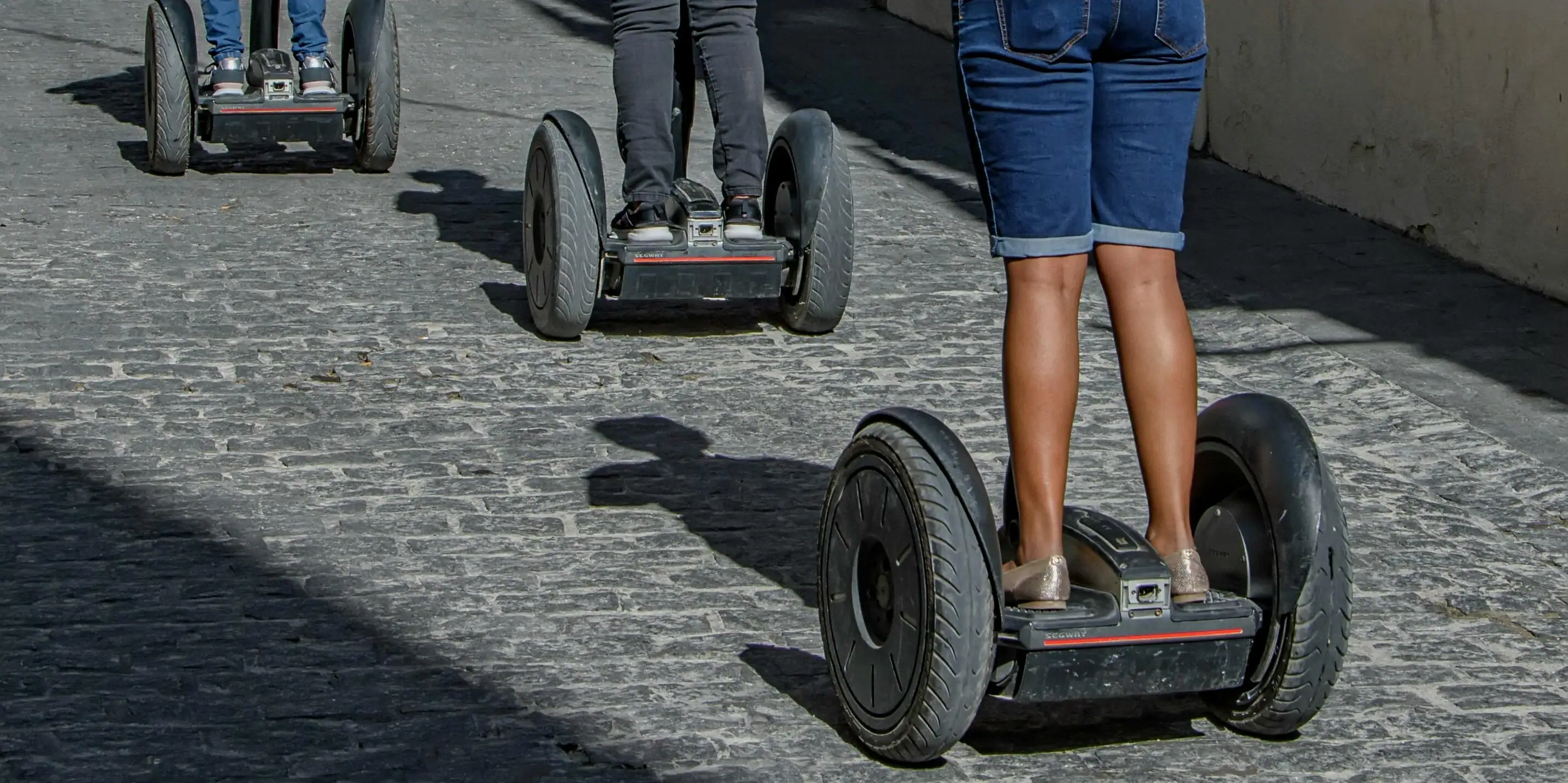 Gruppe von Personen auf Segways im Freien bei Sonnenuntergang.