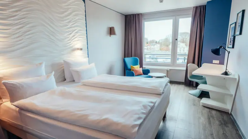 Ein Zimmer mit zwei Betten und einem Tisch.