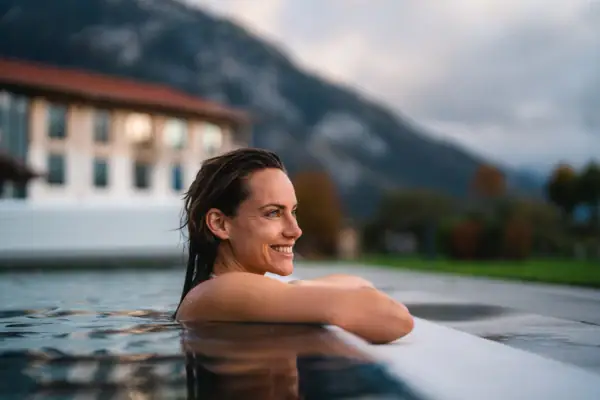 Frau schwimmt in einem Pool im Freien.