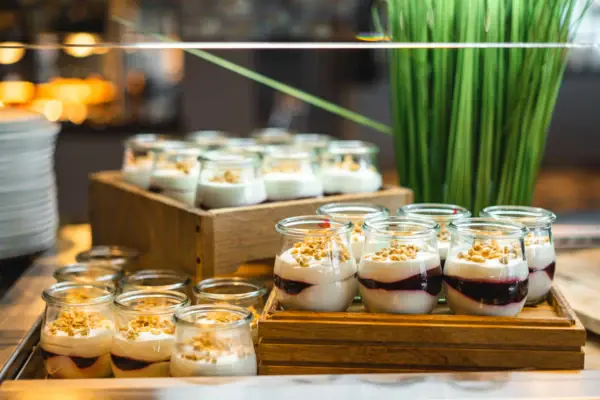 Buffet im JEDERMANNS Ein Tisch mit Desserts in Gläsern.