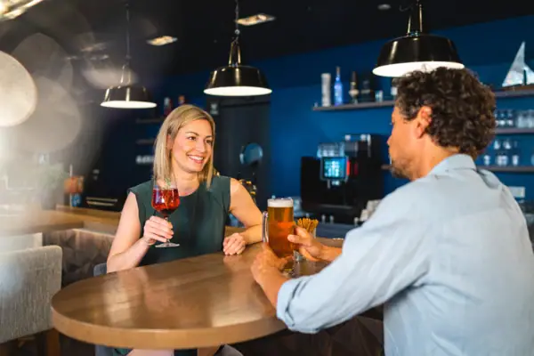 Ein Mann und eine Frau sitzen an einem Tisch mit Getränken.