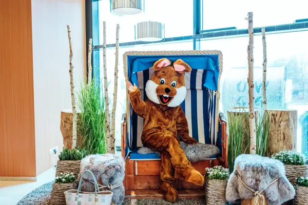 Ostern Eine Person in einem Kleidungsstück sitzt auf einem Stuhl.