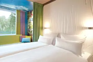 Zimmer aja Bad Saarow Ein Hotelzimmer mit weißen Betten und bunten Vorhängen.